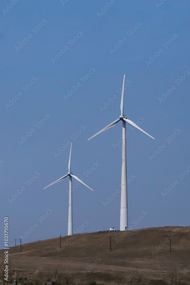 Wind turbine on a cloudless blue sky day. The system of capturing energy from the wind, known as wind power, uses capture towers with three propellers. Wind turbine on a cloudless blue sky day. The system of capturing energy from the wind, known as wind power, uses capture towers with three propellers.