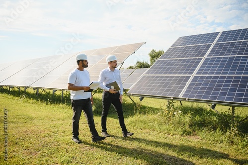 Two engineers or businessmen on the background of solar panels. Renewable energy. Green energy