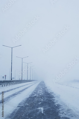 Empty frozen road in winter,
snow blizzard on the highway road, snowstorm on the road