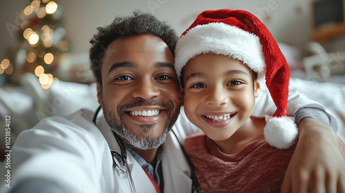kid in hospital sitting on bed in Santa hat , making selfie with doctor.