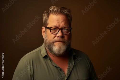 Portrait of a handsome senior man with gray beard and glasses.