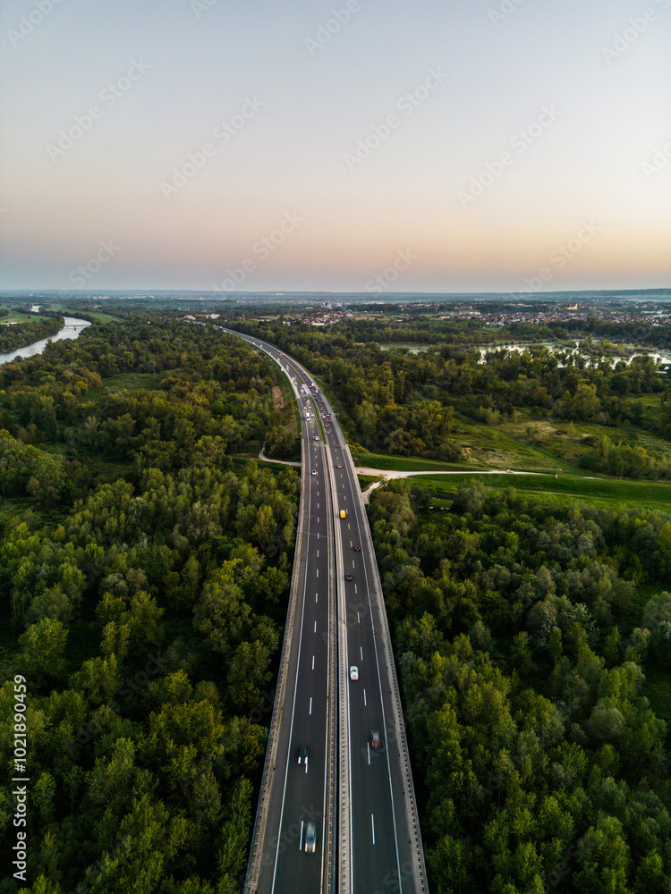 Aerial view of Sava river bridge at sunset and traffic lanes with cars and trucks crossing the river Aerial view of Sava river bridge at sunset and traffic lanes with cars and trucks crossing the river