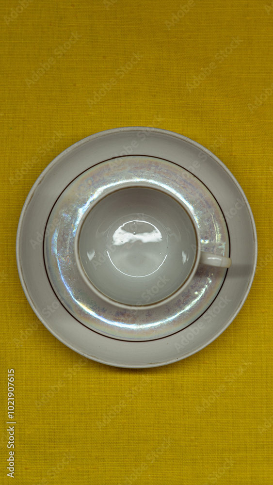 A cup in a saucer on a yellow background, top view. A coffee mug. Espresso Mug A cup in a saucer on a yellow background, top view. A coffee mug. Espresso Mug