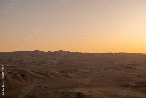 Immense and Dramatic Dune Landscape with Various Buggies Riding by Huacachina in Ica, Peru at Sunset