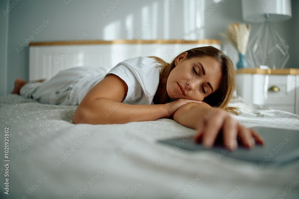 Fototapeta premium Young woman napping on bed.