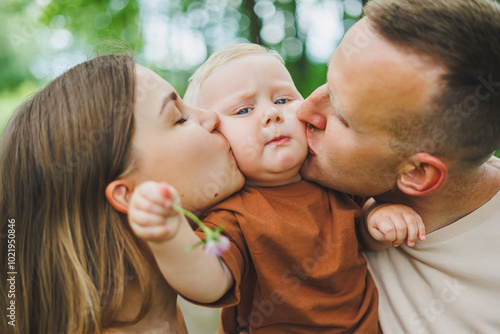 Mom, dad and little son on a walk in the park. Concept of parent time with child. Happy family couple with child in nature.