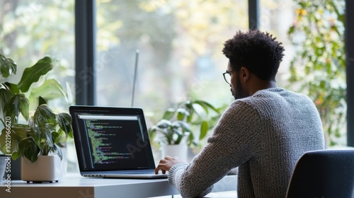 IT professional at desk, coding on laptop, modern office, clean design, copy space