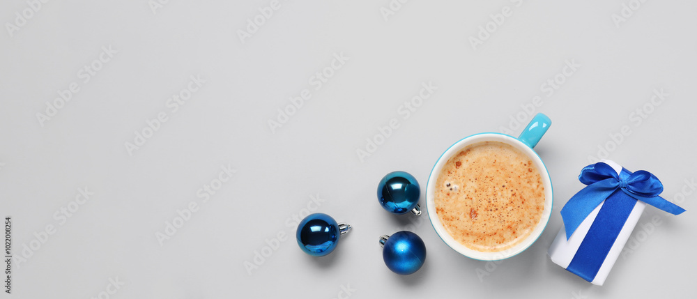 Cup of coffee with gift box and Christmas balls on grey background Cup of coffee with gift box and Christmas balls on grey background