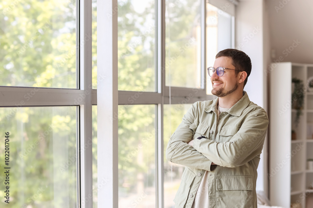 Handsome man in stylish eyeglasses near window at home Handsome man in stylish eyeglasses near window at home