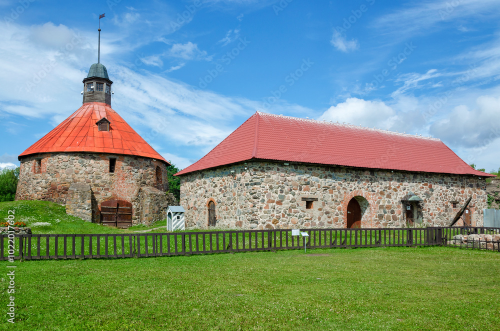 he round gate (Pugachevskaya) tower and the old arsenal in the Korela fortress, on a sunny summer day. Priozersk. he round gate (Pugachevskaya) tower and the old arsenal in the Korela fortress, on a sunny summer day. Priozersk.
