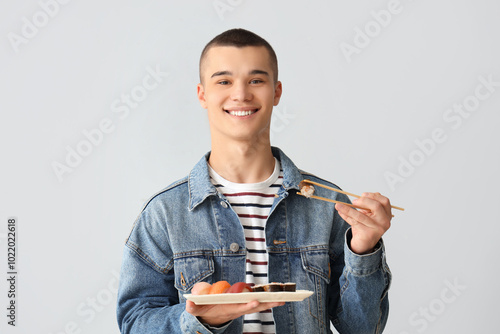 Young man with tasty sushi ...