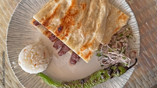 Fotografija Burdur Shish is a local food in Turkey and is served on a plate with rice, pita bread and onion salad
