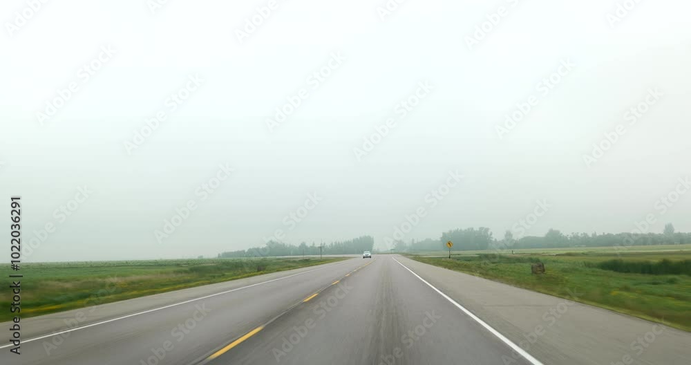 Front driving plate on the foggy highway through plains and mid America farm land Front driving plate on the foggy highway through plains and mid America farm land