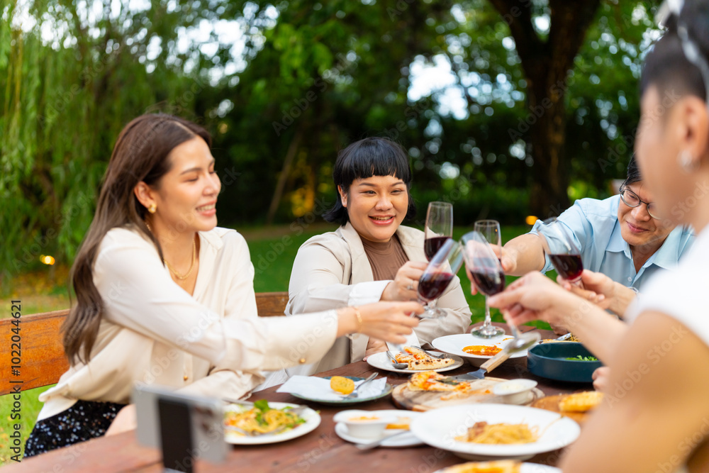 Group of Happy Asian millennial generation people friends enjoy and fun toasting red wine glasses celebration reunion meeting at outdoor dinner party in the garden at restaurant on holiday vacation. Group of Happy Asian millennial generation people friends enjoy and fun toasting red wine glasses celebration reunion meeting at outdoor dinner party in the garden at restaurant on holiday vacation.
