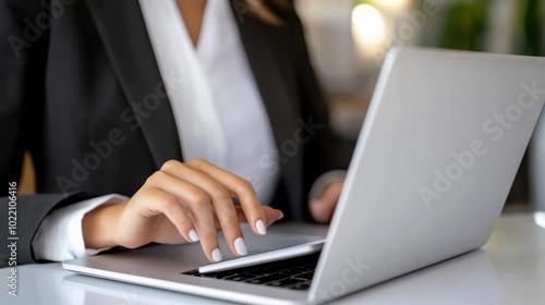 Close-up of Businesswoman Working on Laptop: A focused businesswoman typing on a laptop, with a clean and organized workspace, productivity and concentration in a professional environment 