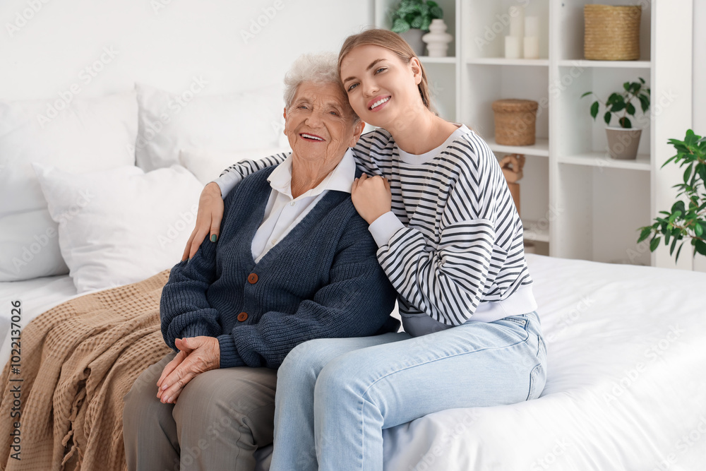 Happy senior woman and her granddaughter sitting in bedroom at home Happy senior woman and her granddaughter sitting in bedroom at home