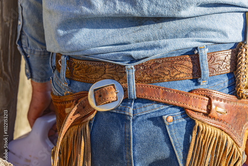 Photos Cowboy wearing leather chaps and blue jeans.