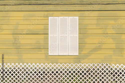 Obraz na płótnie White shuttered window on a yellow painted house. w salonie