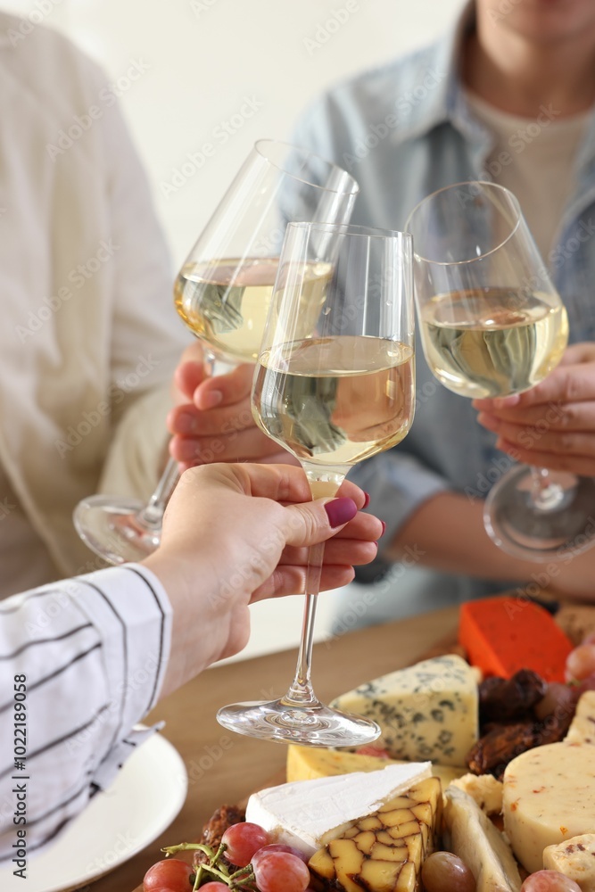 People clinking glasses of wine at served table, closeup People clinking glasses of wine at served table, closeup