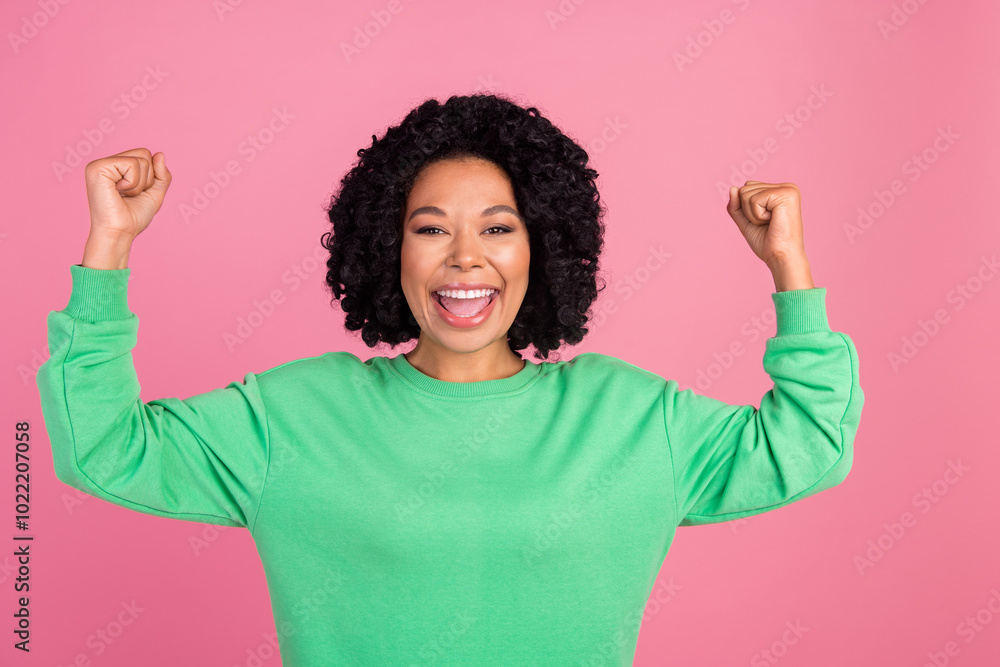 Portrait photo of young charming woman champion competitor with chevelure in green stylish sweatshirt isolated on pink color background Portrait photo of young charming woman champion competitor with chevelure in green stylish sweatshirt isolated on pink color background