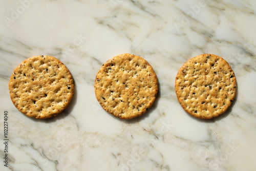 three round multigrain crackers on white marble