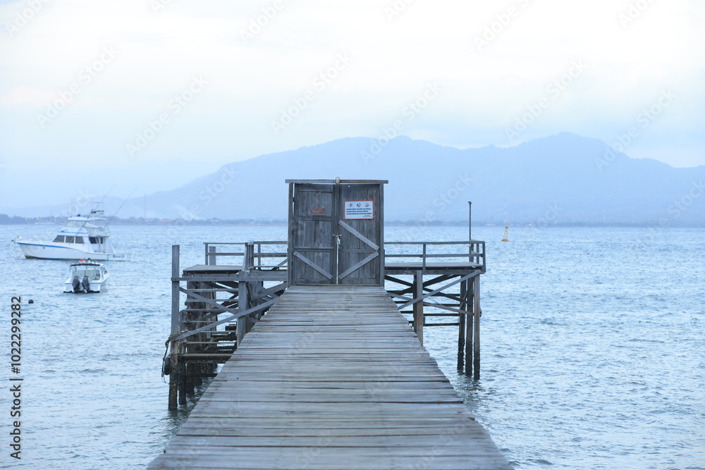 Fototapeta premium Wooden pier leading to the horizon over open waters.