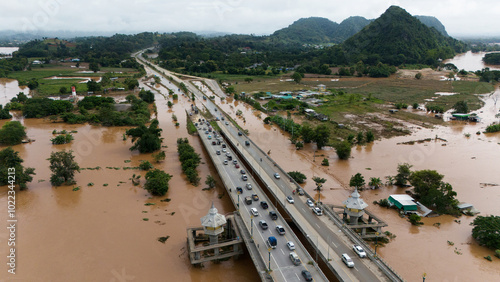 Photos Aerial view of car driving on the bridge after road flooded during typhoon Yagi has swept Chiang Rai province of Thailand