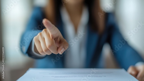 A business professional asserting authority by pointing at a document, showcasing confidence and engagement in a meeting. photo