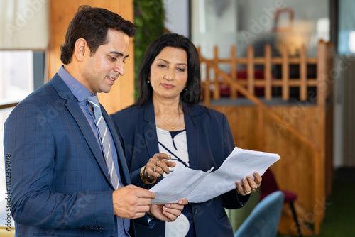 Canvas Print Smiling business persons looking at documents