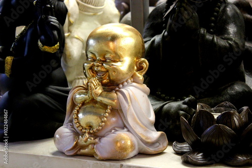 Small statue of laughing buddha in golden color smiling