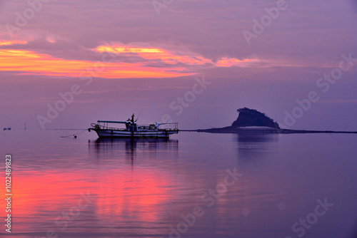 Sunrise over a fishing boat against Shark Island of Yeongjongdo, Jung-gu, Incheon, Korea photo