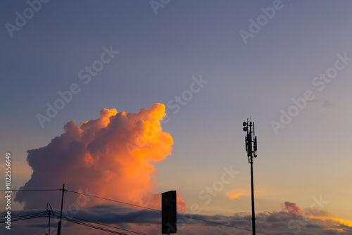 A silhouette of telco tower with beautiful sunset and cloud on the background