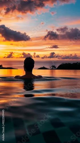Wallpaper Mural Person relaxing in infinity pool at sunset, serene atmosphere. Tranquility and leisure travel concept Torontodigital.ca