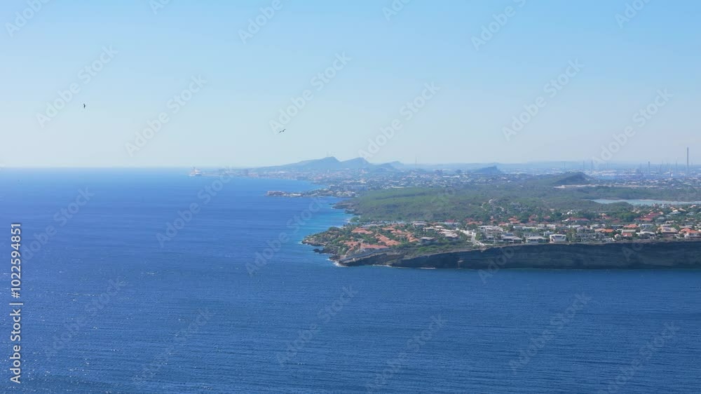 Aerial orbit of frigate birds gliding through the open skies along the coastline of Curacao, set against a stunning backdrop of the ocean and horizon Aerial orbit of frigate birds gliding through the open skies along the coastline of Curacao, set against a stunning backdrop of the ocean and horizon