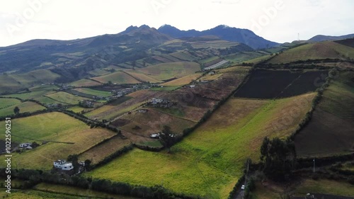 Capturing the serene beauty of rolling hills and vibrant patchwork farmland, this aerial highlights the harmonious blend of nature and agriculture in Romerillo, Ecuador and the Rumiñahui volcano sight