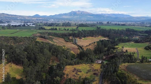 aerial view of the green landscapes of the Ecuadorian highlands in the canton of Mejia, Machachi City, Ecuador with the background of the cloudy Atacazo volcano.