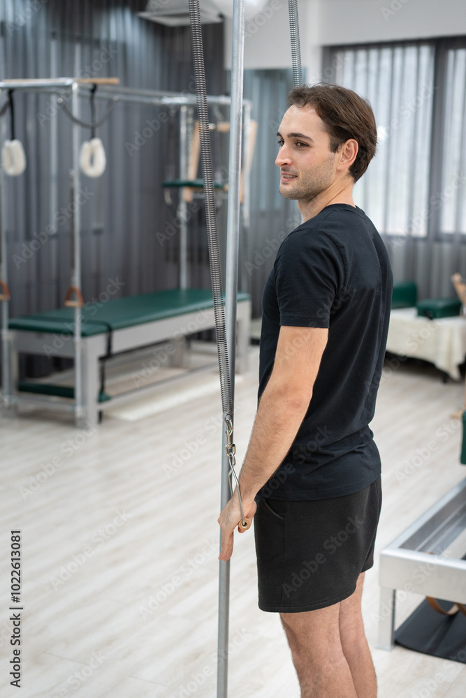 Caucasian men training pilates during class in fitness studio Caucasian men training pilates during class in fitness studio