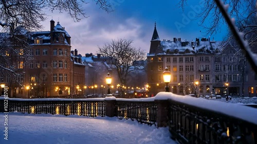 A snowy evening in a European city, with streetlights illuminating the buildings and the snow-covered bridge