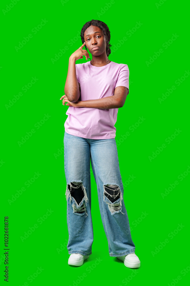 Thoughtful woman pondering in front of a bright green background during a casual moment Thoughtful woman pondering in front of a bright green background during a casual moment