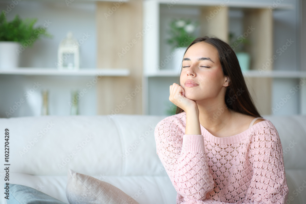 Relaxed woman sitting on a couch with closed eyes Relaxed woman sitting on a couch with closed eyes