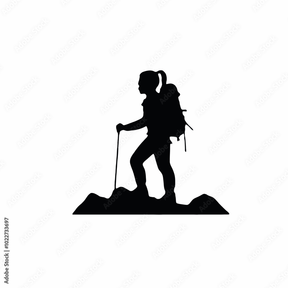 A silhouette of a hiker or mountaineer standing on a rocky peak or mountain summit A silhouette of a hiker or mountaineer standing on a rocky peak or mountain summit