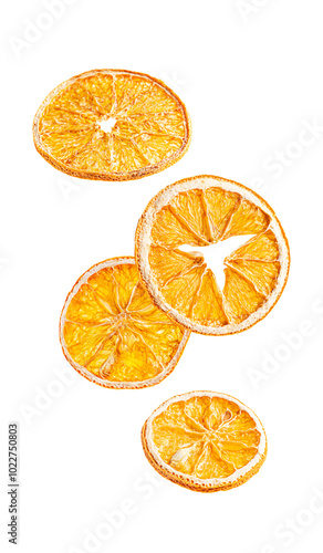 Levitating or flying dried dehydrated aromatic round slices of orange citrus fruit isolated on white background eaten as healthy snack chips or used as ingredient as mulling spice for winter drinks