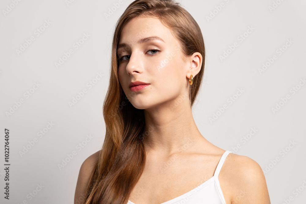 Beautiful woman with pure glowing skin, bare shoulders and long hair pleased with skincare Beautiful woman with pure glowing skin, bare shoulders and long hair pleased with skincare