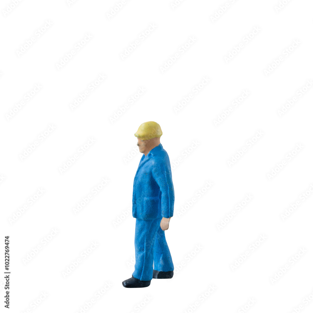 Miniature construction worker dressed in a blue jumpsuit isolate on white background with clipping path Miniature construction worker dressed in a blue jumpsuit isolate on white background with clipping path