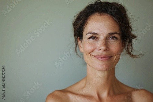 A warm portrait of a smiling  mature woman with bare shoulders against a soft background photo