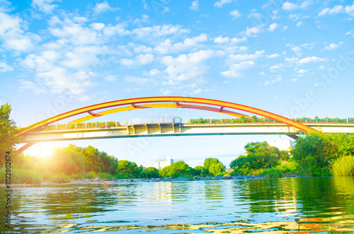 Steel bridge over river with sunset in countryside. photo