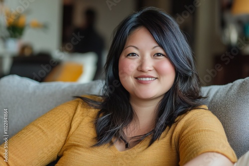 Wallpaper Mural Happy asian american woman relaxing sitting in a comfortable sofa at home Torontodigital.ca