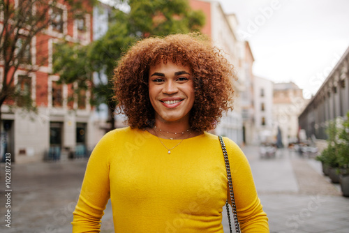 Tableau sur toile Latin gen z transgender woman smiling to the camera in city street