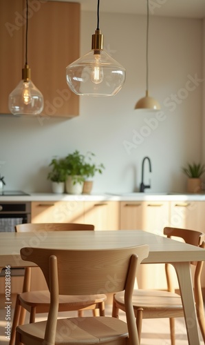 Light wood dining table and chairs in a cozy Nordic-style dining room with natural lighting, modern glass pendant lights, and kitchen cabinets in the background. Front view, warm and inviting atmosphe