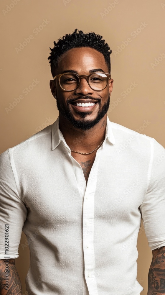 Obraz premium A man with a beard and glasses is smiling and wearing a white shirt